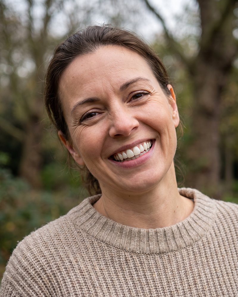 A patient smiling outdoors in a knitted jumper