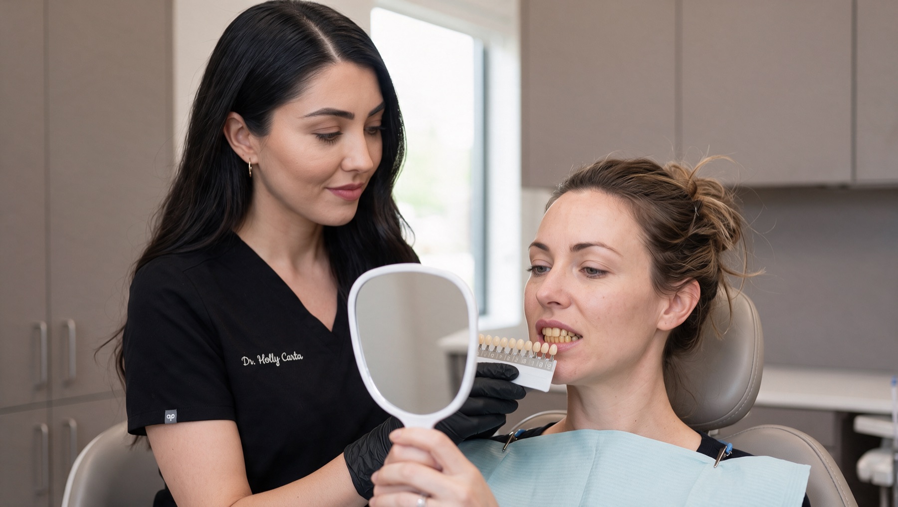 Dr Holly matching tooth shades with a patient at the chair